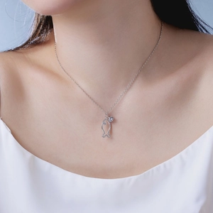 Detail of silver fish pendant with zircons and heart rhinestone on a model's neck