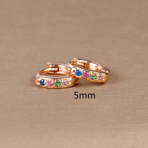 Detailed macro view of 5mm 18K gold huggie earrings with multicolor zircon inlays