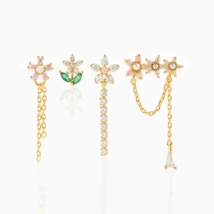 Detailed view of floral gold earrings set featuring zircon crystals and faux pearls