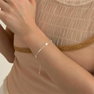 Detail of S925 sterling silver chain bracelet with heart and bear pendants on wrist