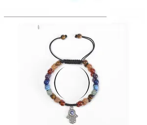 Macro detail of Hamsa Hand charm with blue Evil Eye and 6mm colorful natural stone beads