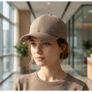 Detail of silver metal logo on dark beige cotton baseball cap for outdoor sun protection