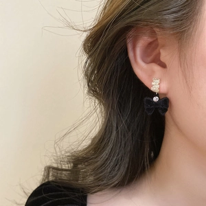 Boucles d'oreilles nœud en velours noir avec cercle doré et détail en zircon scintillant