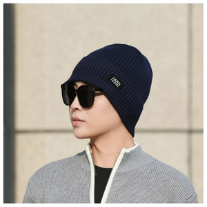 Close-up of navy blue ribbed knit beanie with branded textile label on the side