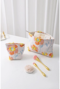 Detail of floral makeup bag set showing orange flower embroidery and two-piece storage set