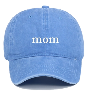 Detailed view of white 'mom' embroidery on a washed blue cotton adjustable baseball cap