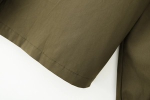 Close-up of military green cotton shirt sleeve with double stitching detail