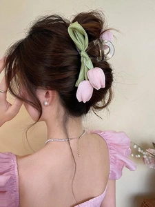 Detail der Tulpen-Haarklammer aus Stoff am Modell mit zarten Netzblumen und grünem Band