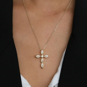 Detailed view of a gold 18k cross pendant necklace with marquise-cut cubic zirconia stones
