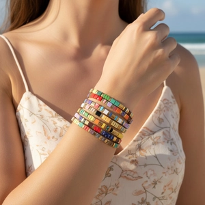 Detailed view of layered bohemian Tila bead bracelets worn on a beach setting