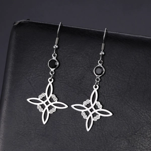 Celtic witch knot silver earrings with black gemstones on a premium leather background