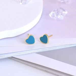 Close-up of heart-shaped blue enamel earrings with gold-plated sterling silver pins