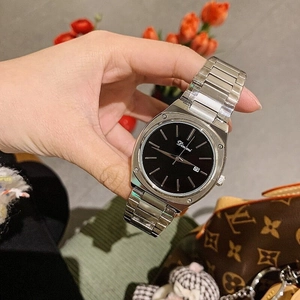 Macro detail of silver steel watch with black dial and calendar display hand-held
