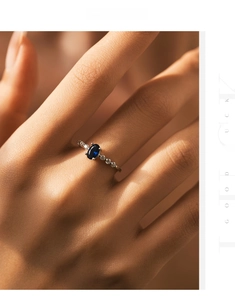 Macro detail of oval blue sapphire ring with sparkling diamond accents on 925 silver band