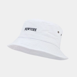 Detailed view of New York embroidery and metal eyelets on white cotton bucket hat