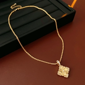 Détail du pendentif trèfle à quatre feuilles doré avec zircons et chaîne torsadée
