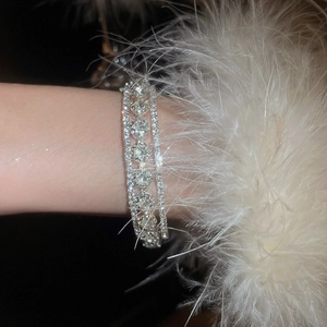 Close-up of multilayer silver bracelet with sparkling round crystals and feather cuff