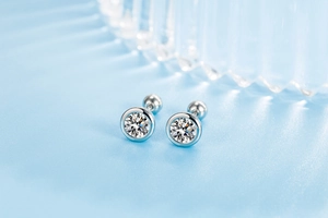 Macro shot of silver zircon screw back stud earrings with round bezel setting details