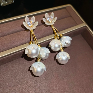 Détails de boucles d'oreilles fleur avec cristaux, pompons dorés et perles rondes