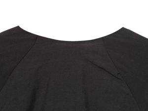 Close-up of the black dress neckline showing fine fabric texture and stitching details