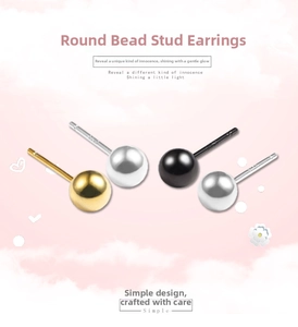 Close-up of minimalist round ball stud earrings in gold, black, and silver finishes