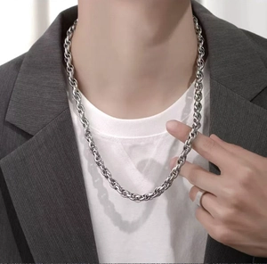 Close-up of a silver twisted rope chain necklace worn by a male model in professional style