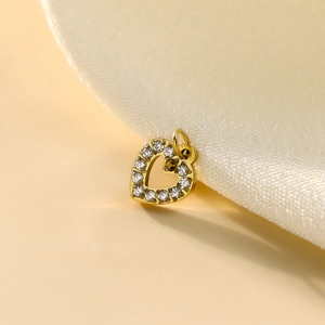 Close-up of golden heart pendant with sparkling clear crystals and metallic shine