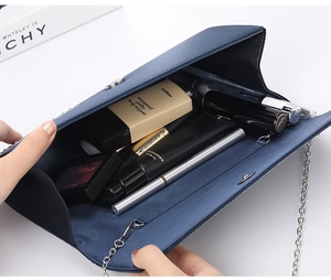 Detail of dark blue satin evening clutch bag showing internal space for makeup items