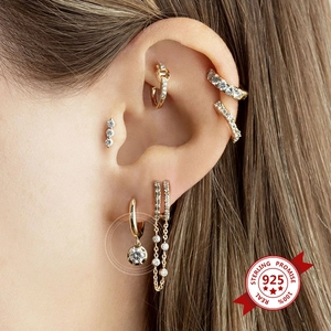 Close-up of gold geometric earrings with pavé zircons and sterling silver posts
