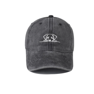 Close-up detail of white cartoon dog embroidery on washed denim baseball cap