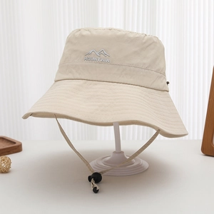 Detailed view of mountain embroidery and adjustable drawstring on beige sun hat