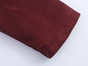 Close-up of deep red faux suede fabric texture showing the soft matte finish on a coat