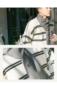 Detailed macro view of the grey cashmere scarf with fringe and material labels
