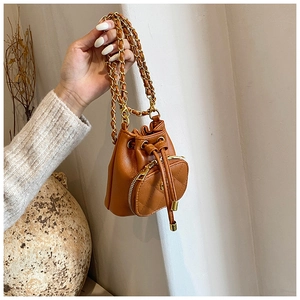 Detail of caramel mini drawstring bucket bag with chain strap and heart purse accessory