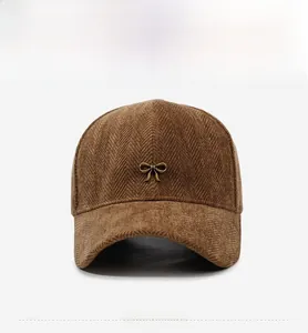 Detail of brown herringbone corduroy baseball cap with a gold metal bow buckle