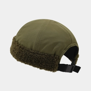 Dettaglio del cappello docker verde militare con bordo in sherpa e fibbia regolabile sul retro