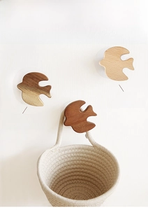 Close-up of bird-shaped wooden wall hooks in acacia and beech wood with grain details