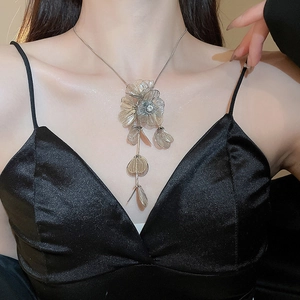 Detail of silver flower tassel necklace with rhinestone petals on a female model