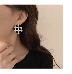 Close-up of model wearing vintage black and white checkered resin square stud earrings