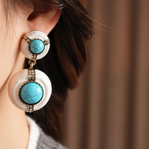 Close-up of vintage resin drop earrings with turquoise texture and small crystals