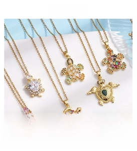 Close-up of gold-plated sea turtle necklaces with colorful zircon crystal stones