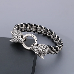 Close-up of vintage double wolf heads and black braided leather bracelet for men