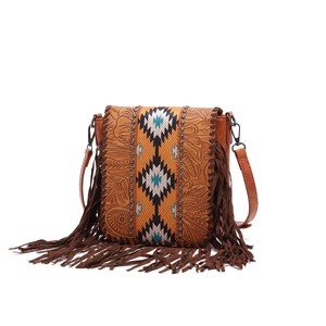Close-up of bohemian leather bag featuring floral embossing and woven tribal strap