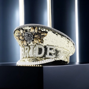 Detailed view of champagne gold bride hat with sequins, pearls and BRIDE lettering