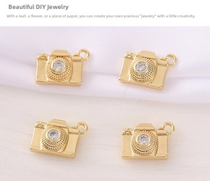 Close-up of four gold-plated camera pendants with cubic zirconia for DIY jewelry making