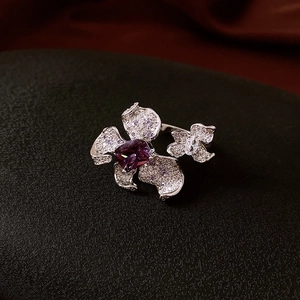 Macro detail of a silver ring featuring purple square zircon and floral butterfly motifs