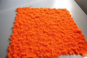 Detailed texture of thick orange artificial moss turf showing soft synthetic fibers