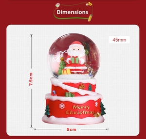 Detailed size view of a mini Christmas snow globe with Santa Claus and festive base
