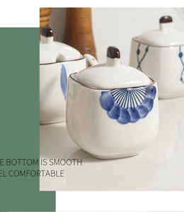 Close-up of Japanese ceramic spice jar with blue pattern, lid and spoon, smooth bottom