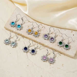 Daisy flower earrings set with colorful cubic zirconia on beige marble stone